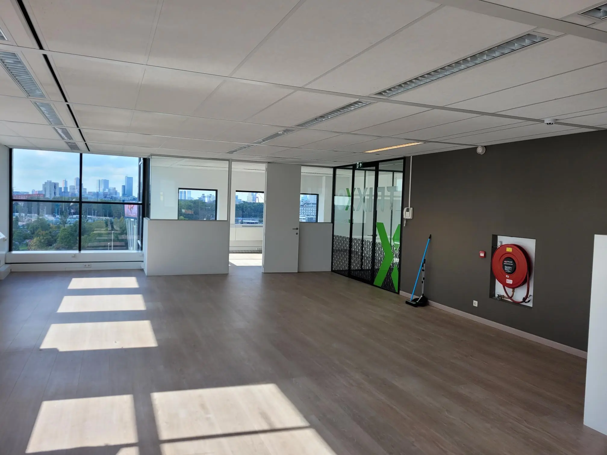 Licht, leeg kantoorpand aan het Rivium Quadrant met uitzicht op de skyline van Rotterdam.